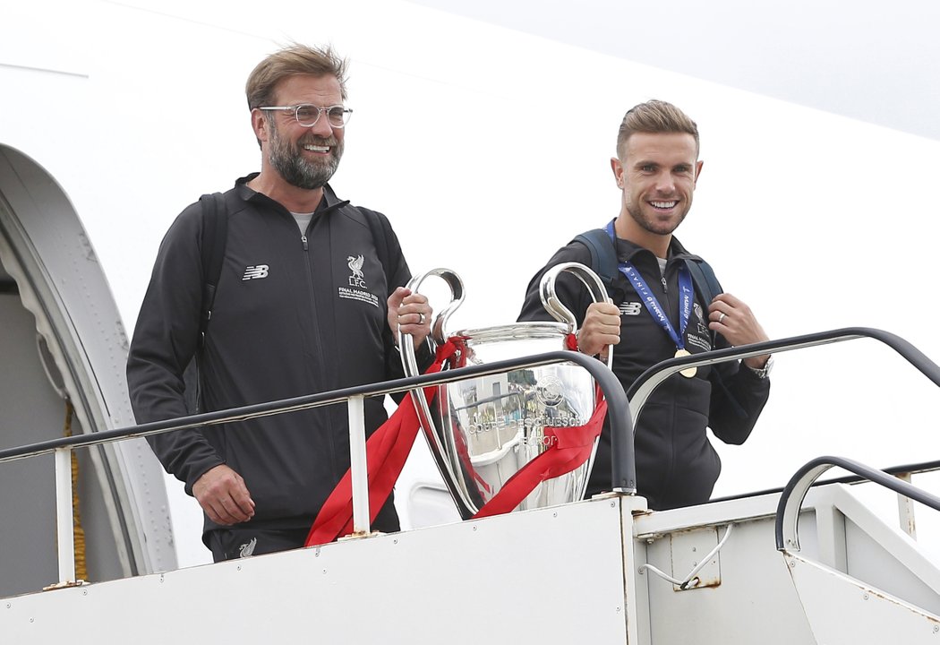 Návrat do Liverpoolu. Trofej pro vítěze Ligy mistrů ukázal trenér Jürgen Klopp a kapitán Jordan Henderson.