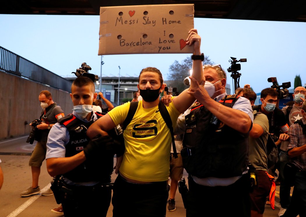 Zadržený fanoušek před stadionem Nou Camp, který protestoval proti odchodu Lionela Messiho