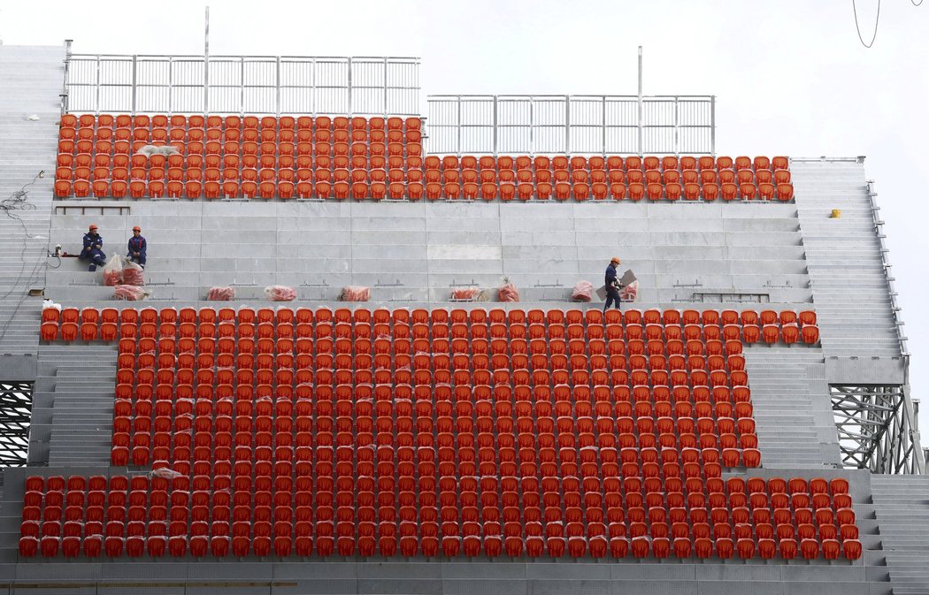 Dělníci dokončují tribunu, která bude vyčnívat ze stadionu v Jekatěrinburgu
