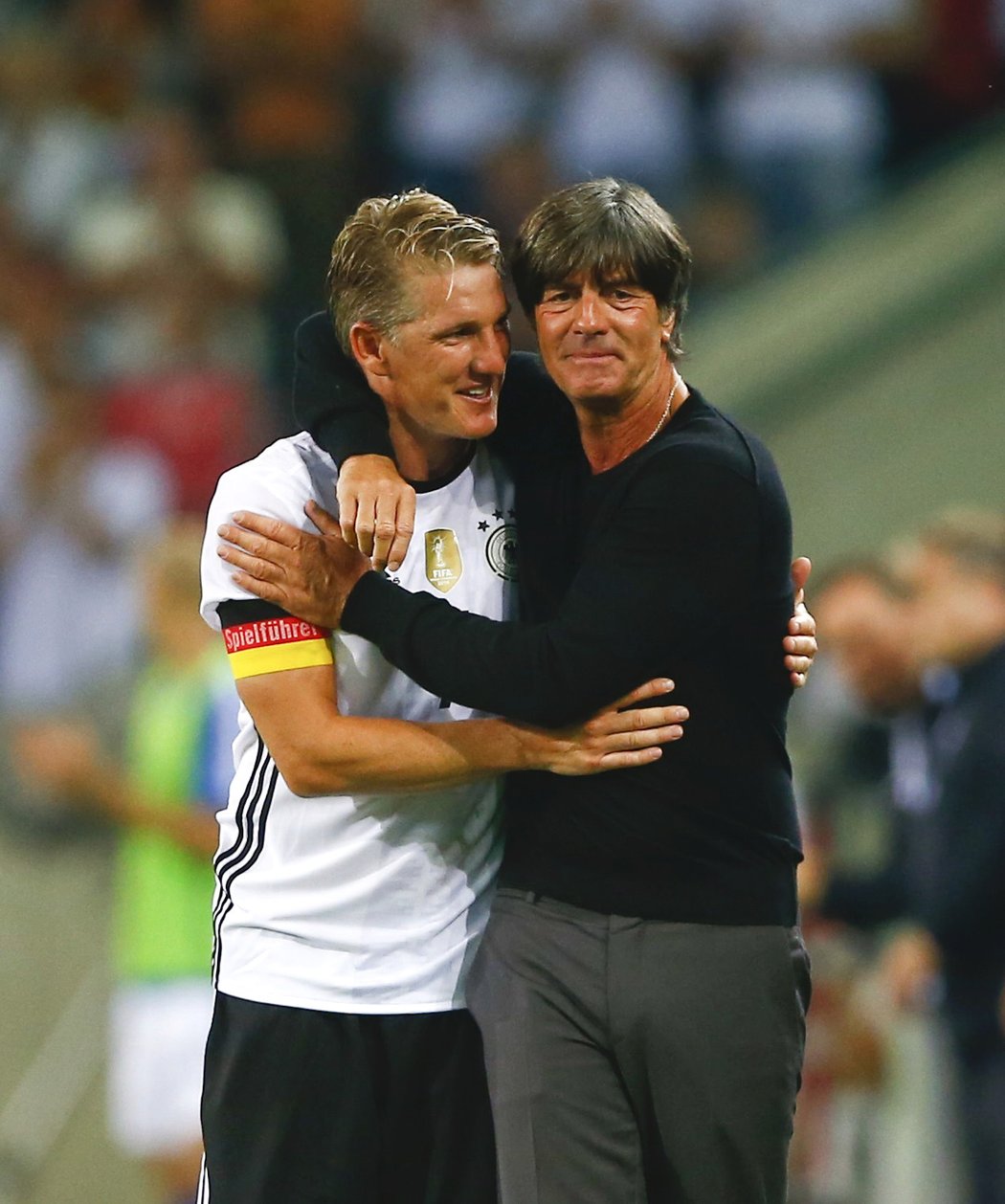 Bastian Schweinsteiger s kapitánskou páskou Spielführera a koučem Joachimem Löwem