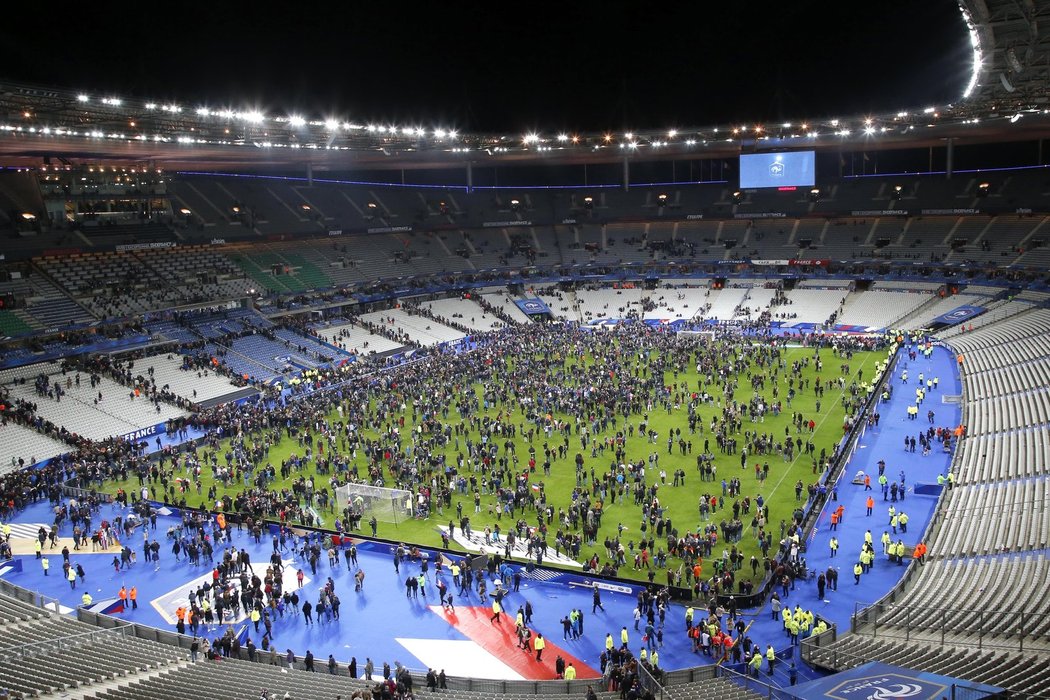 Fanoušci po sérii výbuchů v okolí stadionu obsadili hřiště