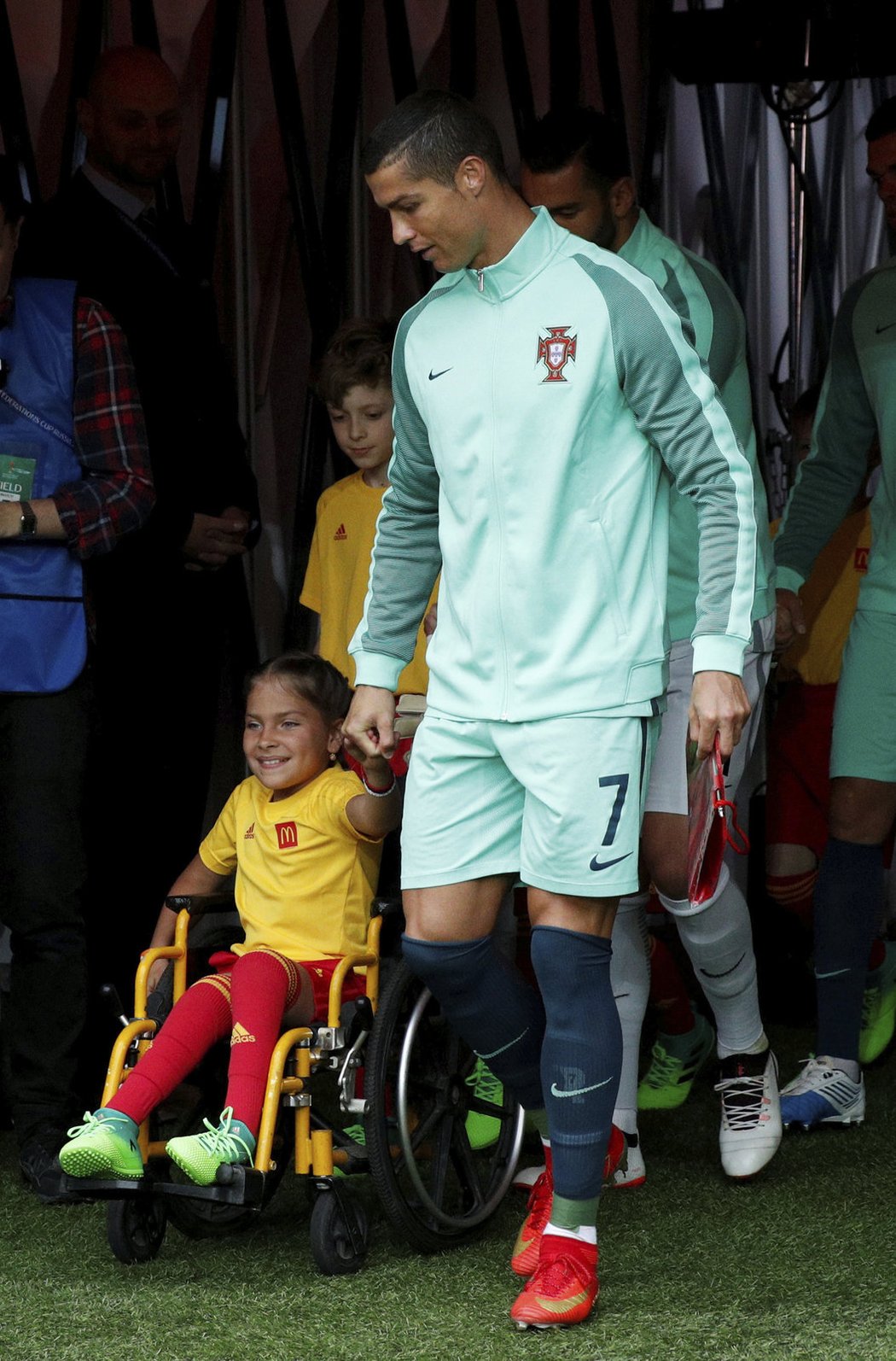 Cristiano Ronaldo vstupuje na hřiště za doprovodu dívky na vozíčku