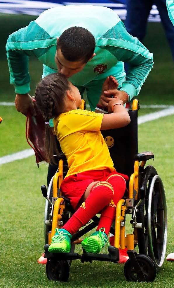 Dojemný moment. Cristiano Ronaldo políbil dívku na vozíčku, která ho doprovodila na hřiště.