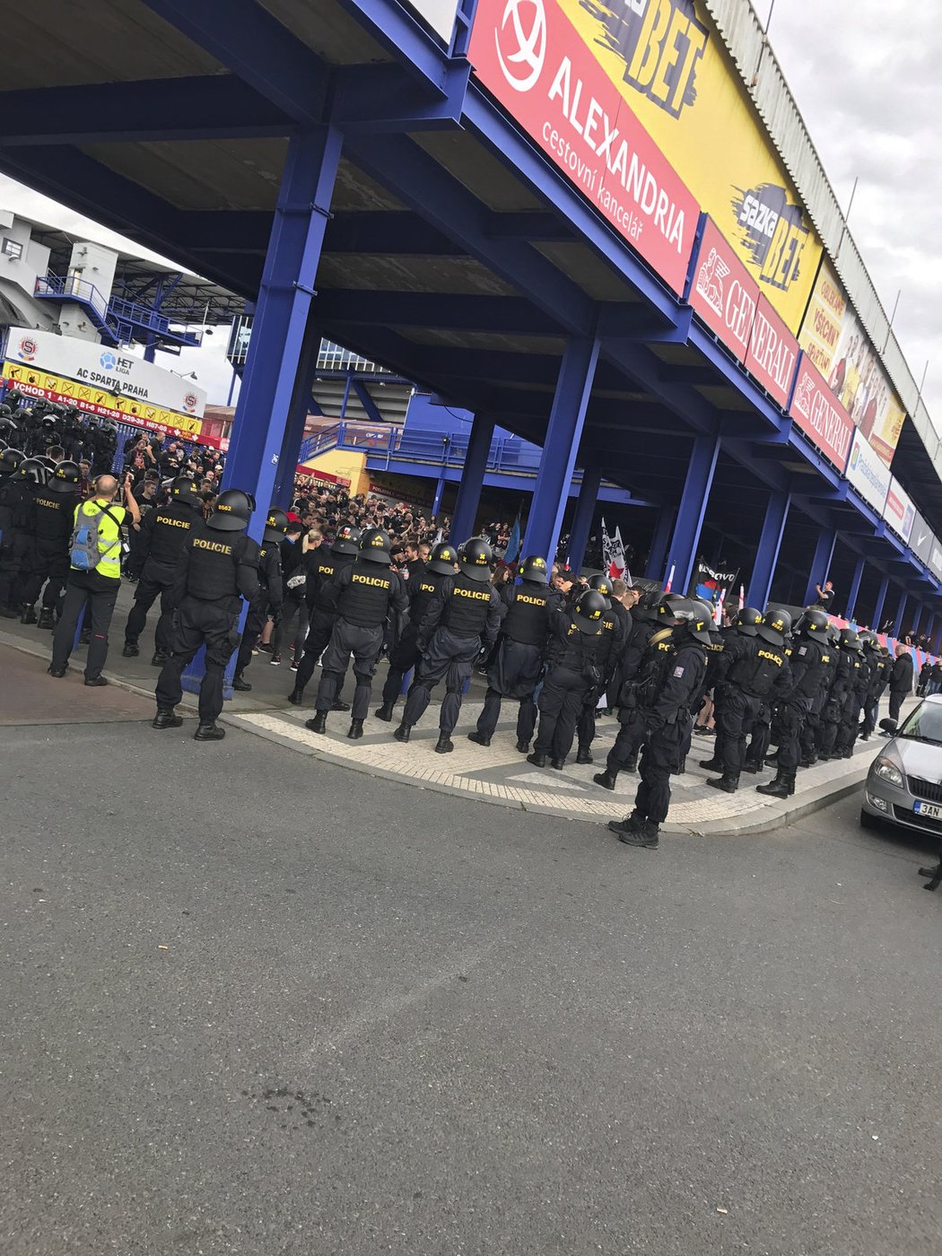 Fanoušci Sparty před začátkem pochodu k Edenu v obležení policistů