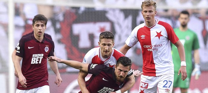 Lukáš Vácha ze Sparty brání míč před útočníkem Slavie Milanem Škodou