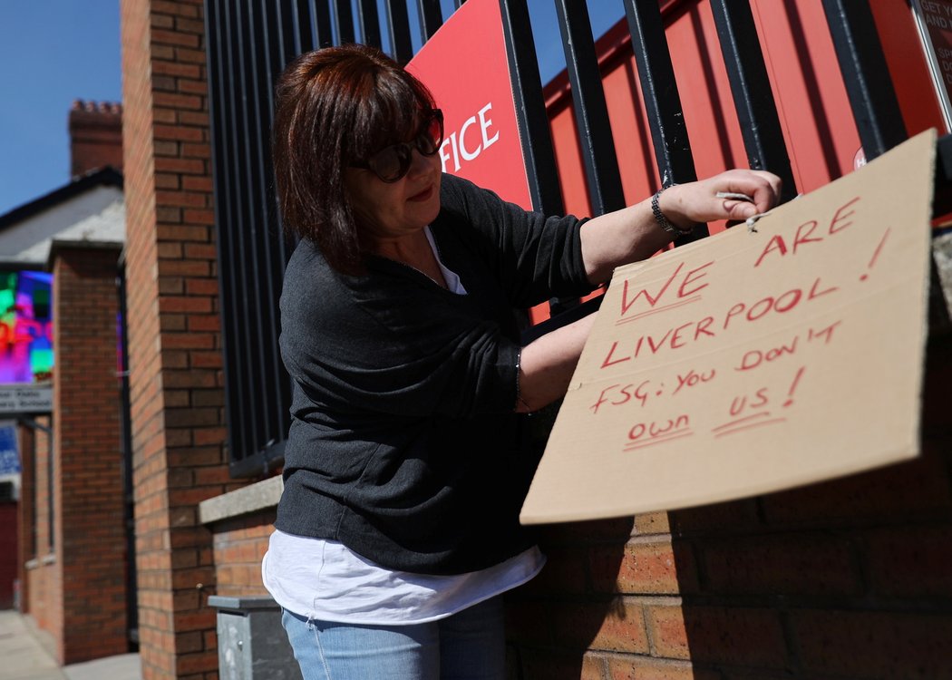 Fanynka Liverpoolu připevňuje vzkaz, který protestuje proti vzniku Superligy