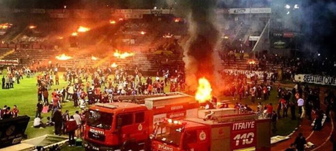 Hasiči na stadionu v tureckém Eskisehirsporu hasí ohně po řádících domácích fanoušcích.