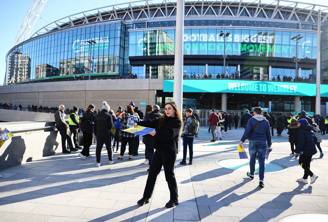 Fanynka rozdává ukrajinské vlajky před finále Ligového poháru Chelsea - Liverpool