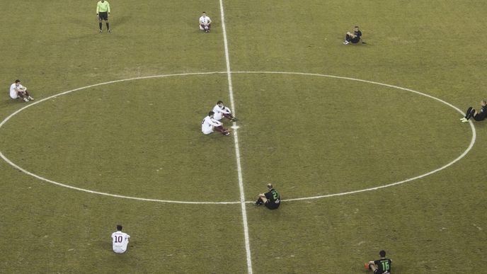 Oba týmy si před začátkem zápasu sedli na trávník. 