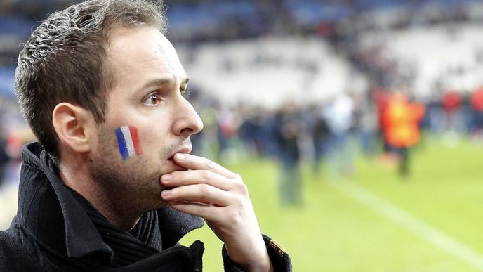 Fotbalový fanoušek na stadionu Stade de France reaguje na zprávu o teroristických útocích