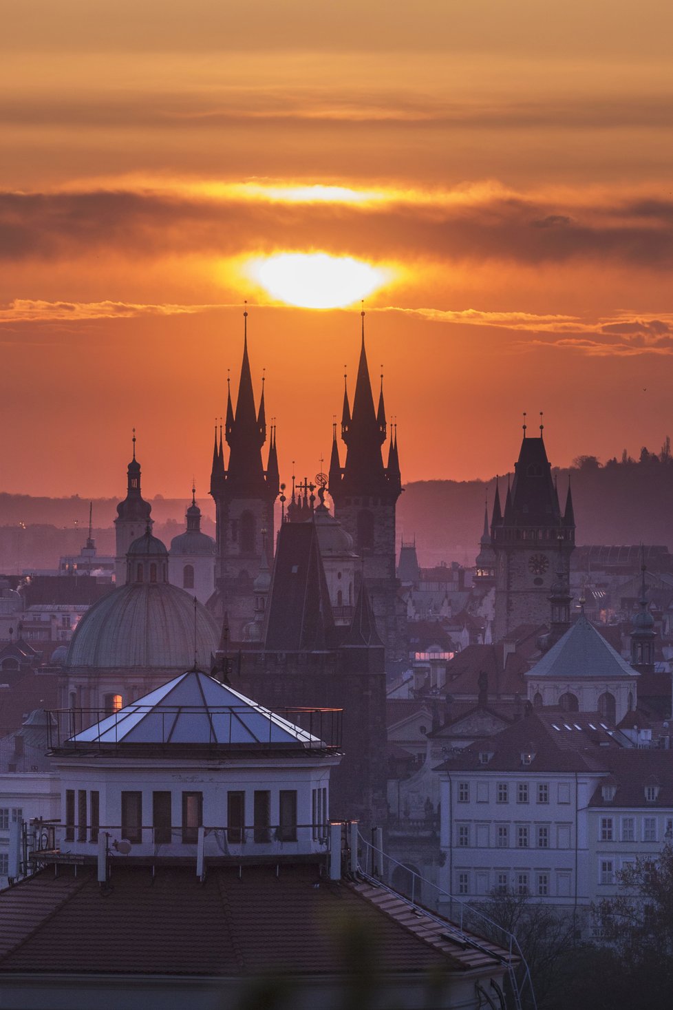 Na slunce mezi věžemi Týnského chrámu čeká řada fotografů.