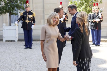 První dáma Francie Brigitte Macronová si kvůli vykloubenému rameni s manželkou řeckého premiéra Marevou Grabowskou-Mitsotakisovou potřásla levou rukou.
