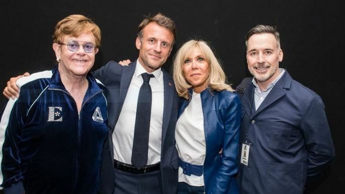 Francie hoří, ale Elton John, Emmanule Macron, Brigitte Macronová a David Furnish se usmívají.