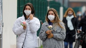 Lidé přinášejí květiny před budovu školy Collège du Bois d&#39;Aulne na pařížském předměstí, kde působil zavražděný učitel dějepisu (17. 10. 2020)