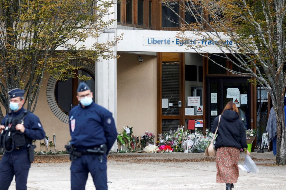 Lidé přinášejí květiny před budovu školy Collège du Bois d&#39;Aulne na pařížském předměstí, kde působil zavražděný učitel dějepisu (17. 10. 2020)