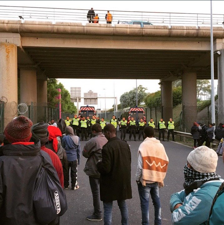 Nelegální imigranti se snaží dostat z Francie do Velké Británie. Policisté se je snaží zadržet.