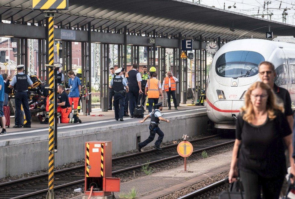 Eritrejec shodil ženu s chlapcem (†8) pod vlak. Žil si ve Švýcarsku a má tři děti. Lidé pokládají na nádraží ve Frankfurtu věnce (30.7.2019)