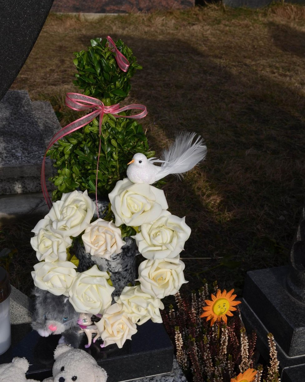Rodiče dvou sourozenců přinesli na hrob bílé růže.