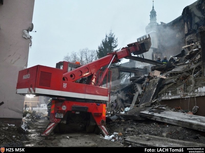 Použití těžké techniky při strhávání jedné ze stěn domu