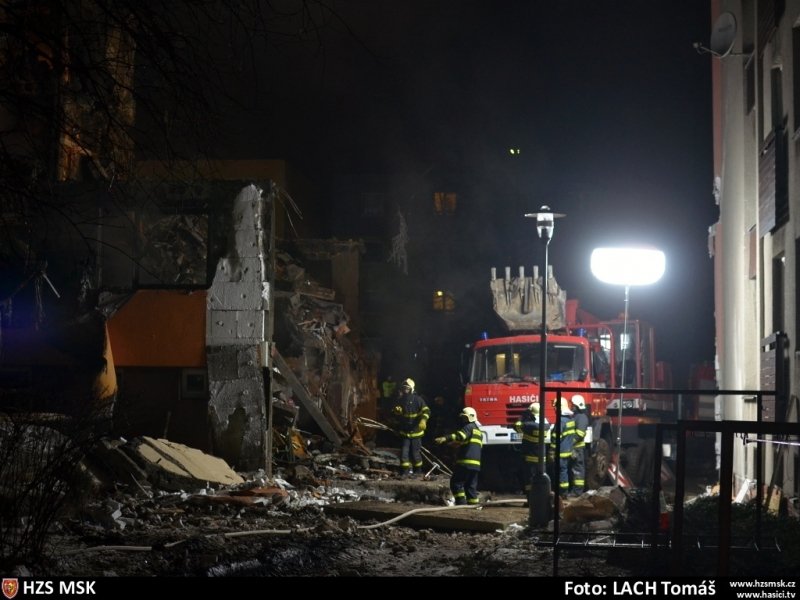 Použití těžké techniky při strhávání jedné ze stěn domu