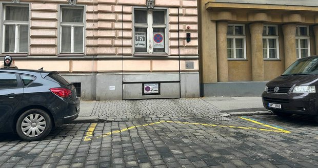 Nenápadný vjezd do podzemních garáží v Kamenické ulici v Praze 7 splývá s fasádou domu. Na první pohled působí jako běžná část domu.