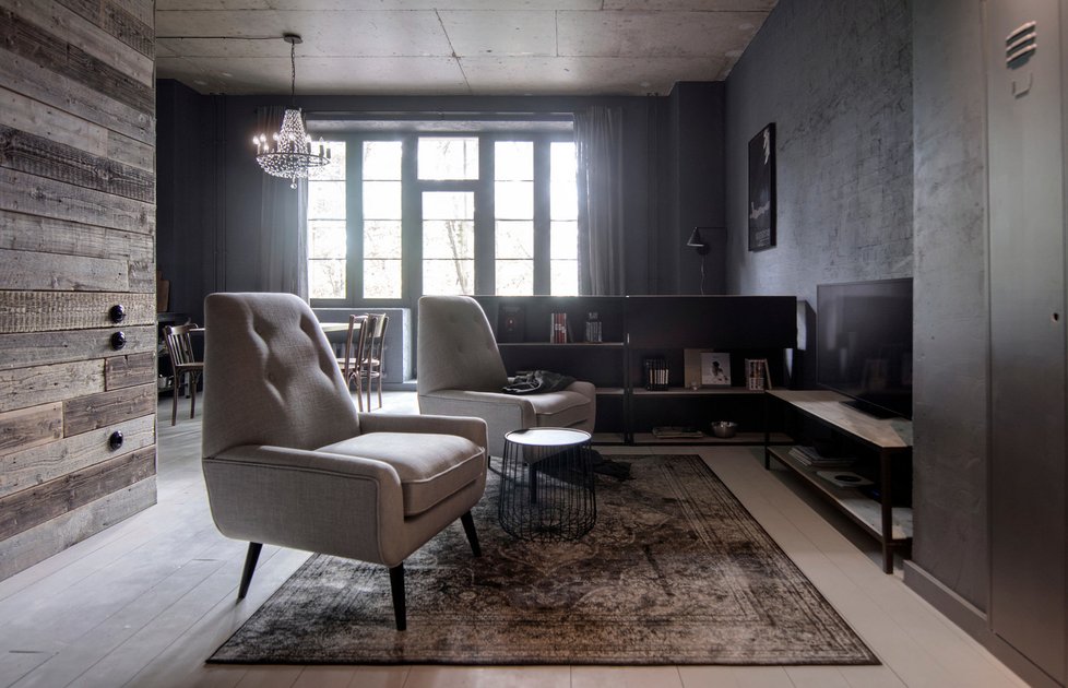 Přečalouněná vintage křesílka a prošlapaný koberec dávají obývací části nostalgický šmrnc.