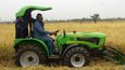 Ghanský prezident John Dramani Mahama řídí český malotraktor na rýžovém poli