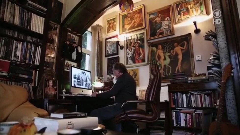 Karel ve své pracovně, vyzdobené vlastními obrazy, používá počítač Apple iMac 27.