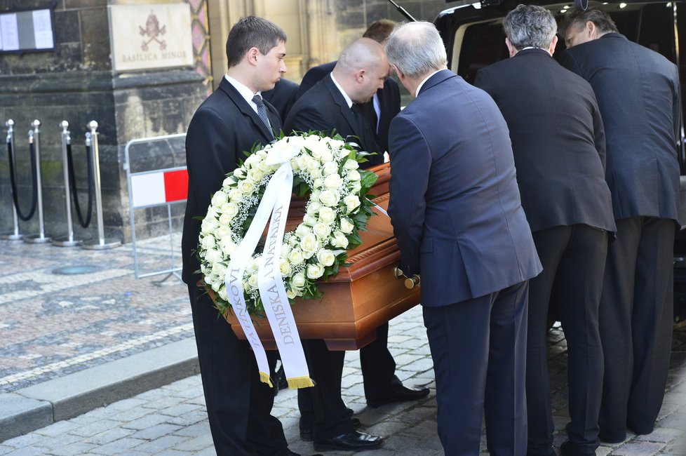 Šestice mužů, zřejmě z řad Grossových přátel a příbuzných, vynáší rakev s jeho ostatky z baziliky.