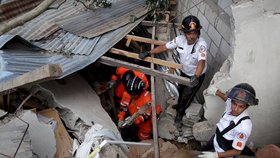 Záchranné týmy vynášejí těla obětí sesuvu půdy v Guatemale. Stovky záchranářů se snaží najít pohřešované.