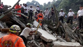 Záchranné týmy vynášejí těla obětí sesuvu půdy v Guatemale. Stovky záchranářů se snaží najít pohřešované.