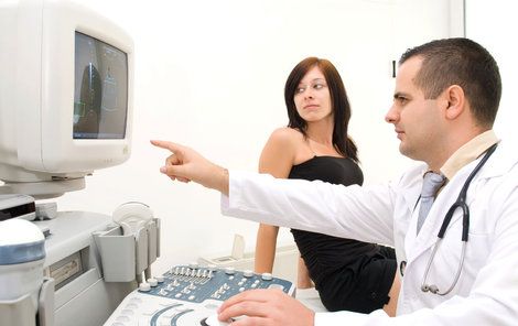 Lékař ukazuje ženě myom v její děloze.