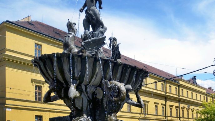Hanácká kasárna v Olomouci na pozadí barokní kašny Tritonů.