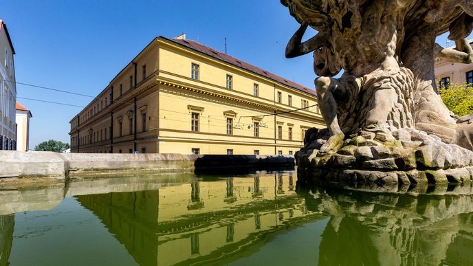 Hanácká kasárna v Olomouci na pozadí barokní kašny Tritonů.