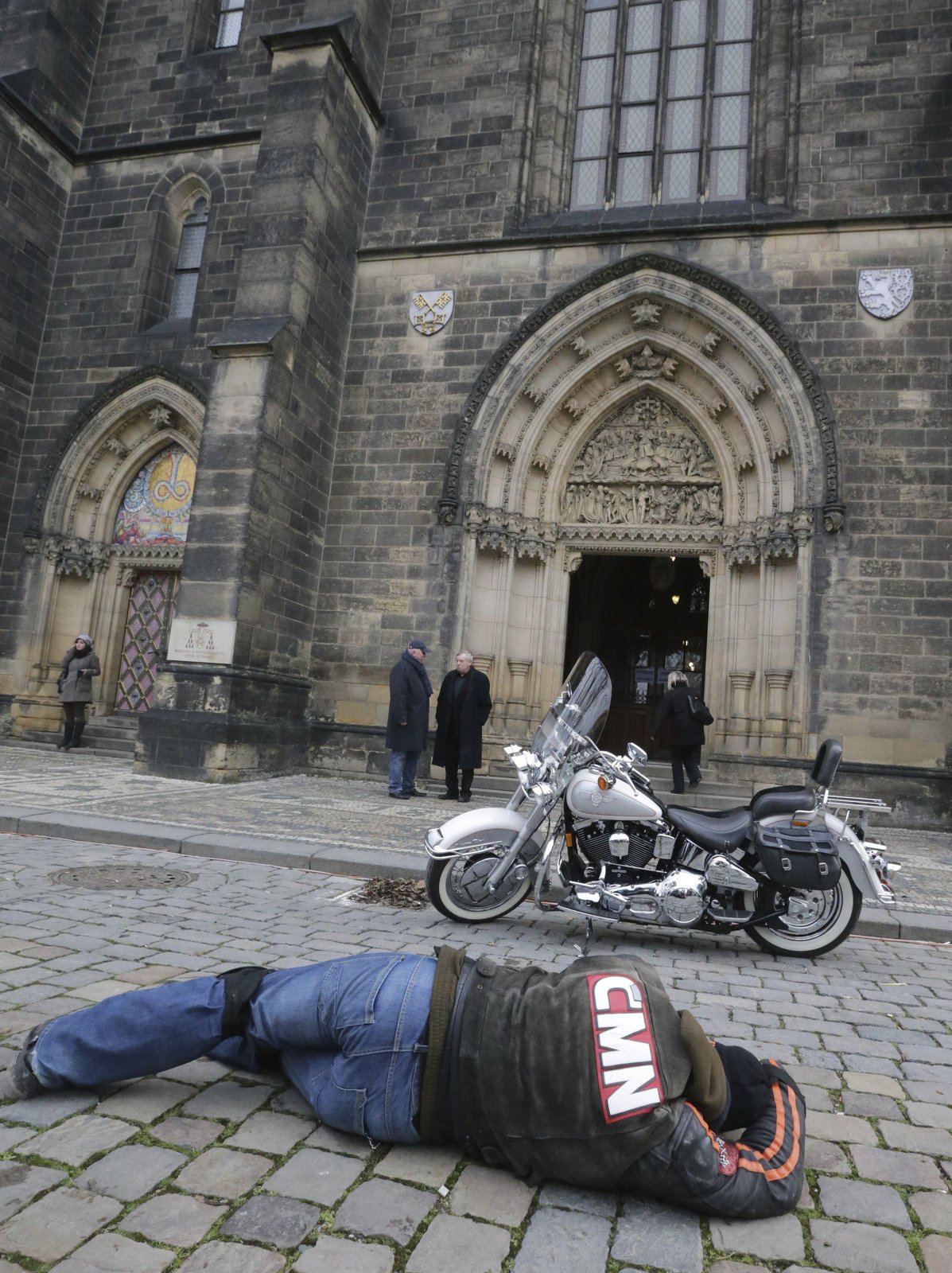 Fotograf z motorkářských novin se snaží ulovit co nejlepší snímek Hapkova motocyklu a kostela na Vyšehradě.