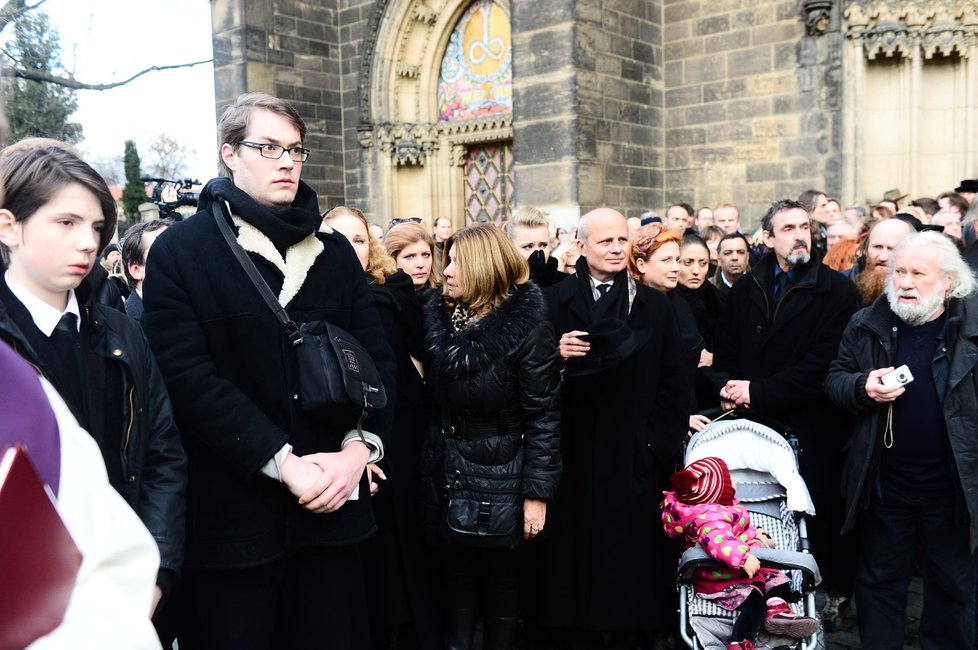 Rodina a přátelé pohledem vyprovázejí auto, které odváží rakev s Petrem Hapkou