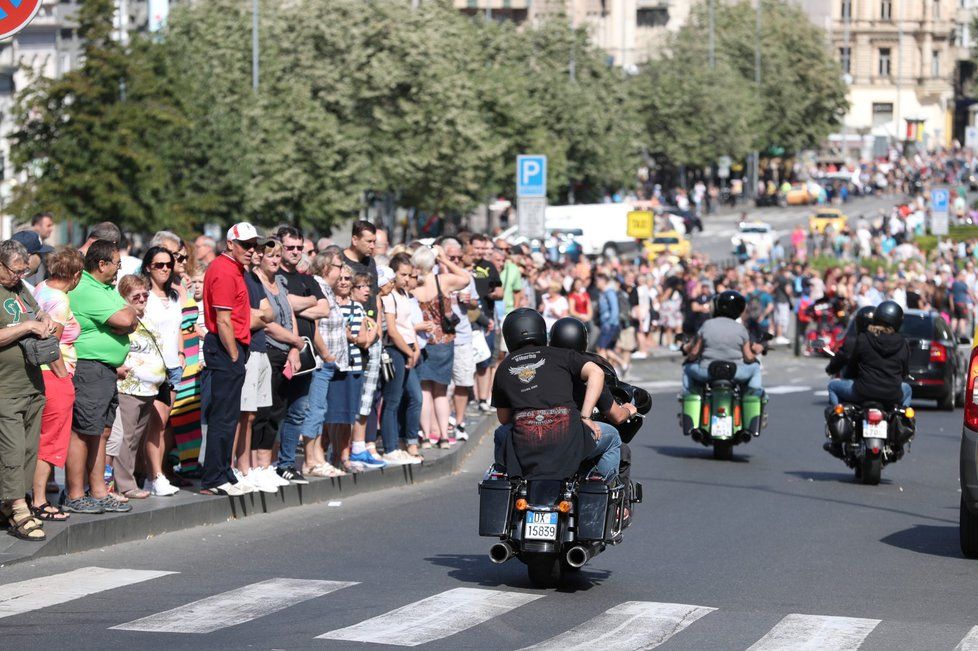 Motorkáři vyrazili na spanilou jízdu, zvědaví Pražané jim nadšeně mávají.