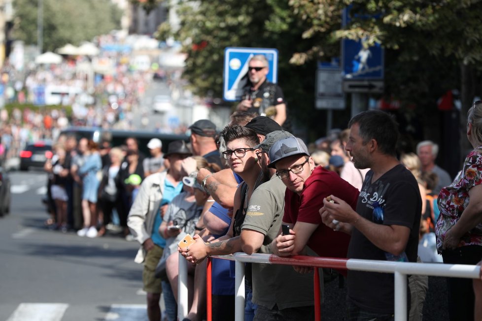 Motorkáři vyrazili na spanilou jízdu, zvědaví Pražané jim nadšeně mávají.