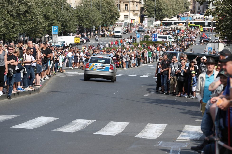 Motorkáři vyrazili na spanilou jízdu, zvědaví Pražané jim nadšeně mávají.