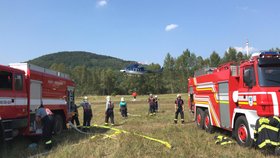Hasiči likvidují požár trávy: Zasáhnout musí vrtulník!