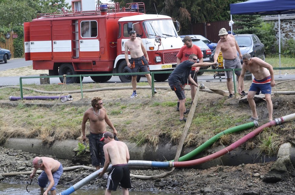 Dobrovolní hasiči z Horního Hradiště zajišťují čerpání vody z rybníka na návsi do hasičských cisteren.