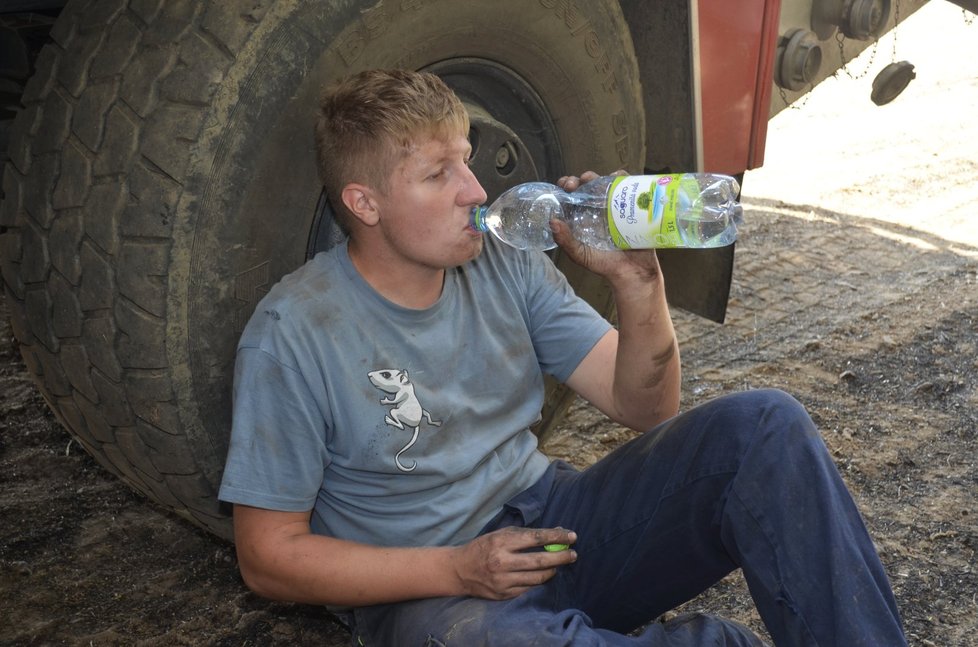 Hasič Michal Soukup (22) už má ohně plné zuby. Chvilku oddychu využívá k tomu, aby se napil vody.