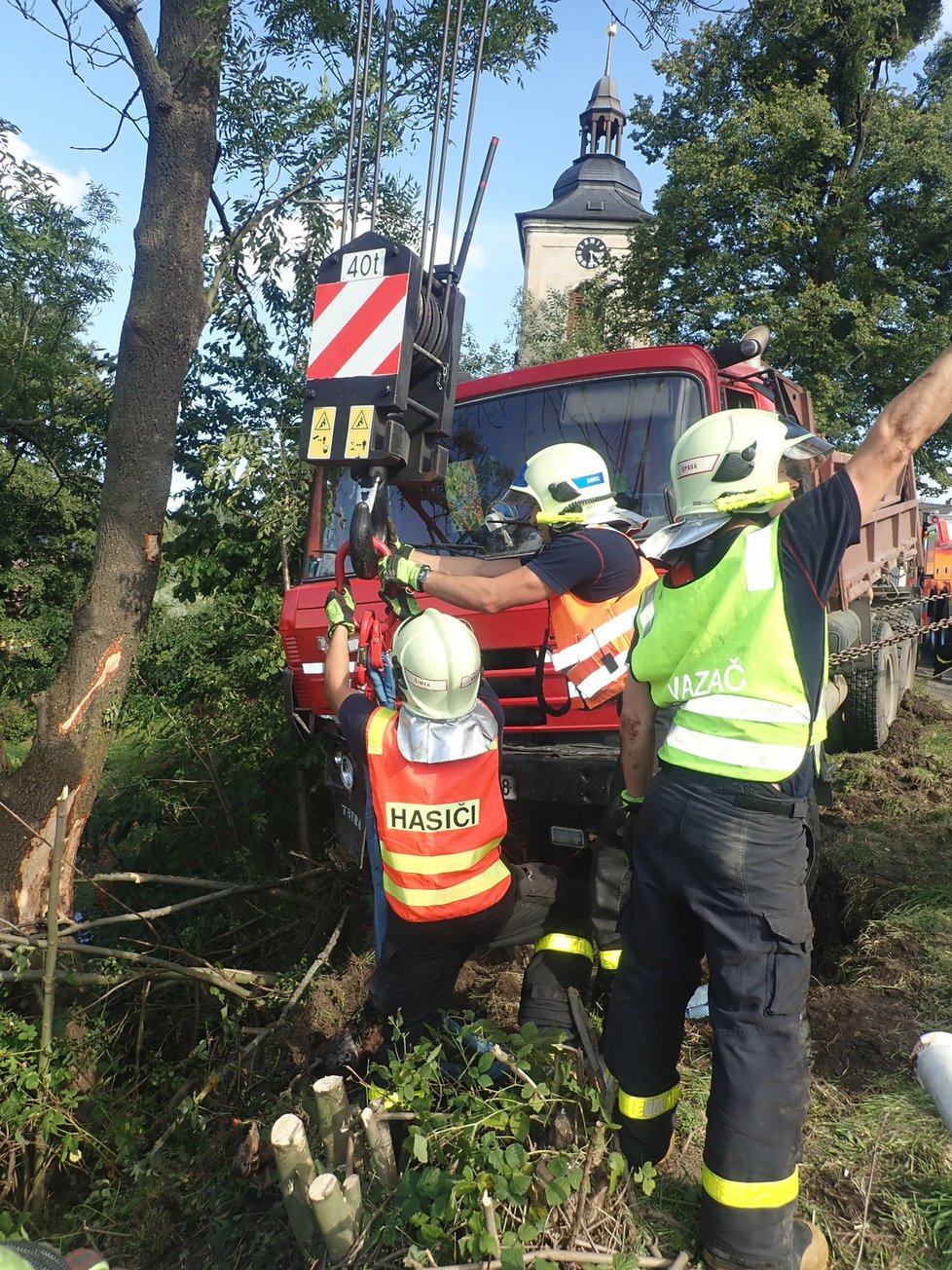 Řidič nákladní tatrovky se patrně řádně nevěnoval řízení a sjel v Jakartovicích na Opavsku na krajnici, kde zapřel auto o strom. Zůstalo viset nad požární nádrží. Hasiči při jeho vyprošťování předvedli profesionální práci.