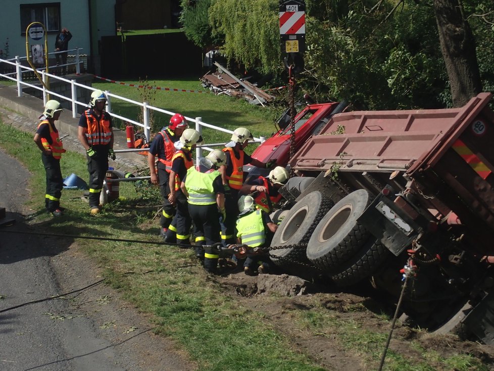 Řidič nákladní tatrovky se patrně řádně nevěnoval řízení a sjel v Jakartovicích na Opavsku na krajnici, kde zapřel auto o strom. Zůstalo viset nad požární nádrží. Hasiči při jeho vyprošťování předvedli profesionální práci.