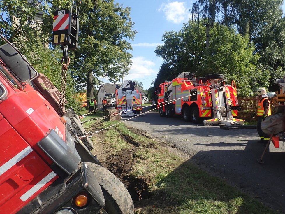 Řidič nákladní tatrovky se patrně řádně nevěnoval řízení a sjel v Jakartovicích na Opavsku na krajnici, kde zapřel auto o strom. Zůstalo viset nad požární nádrží. Hasiči při jeho vyprošťování předvedli profesionální práci.