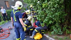 Když hasiči mříž kanálu odřezávali, kryli ženu i sebe před jiskrami létajícími z rozbrušovací pily.