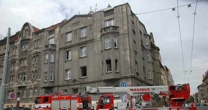 Hořelo v bytu v 1. patře. Na snímku jsou to okna nad hasičským autem