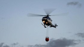 Hasičům při požáru pomáhal policejní vrtulník s vodním vakem.