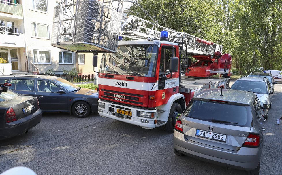 Hasičský vůz se kvůli špatně špatně parkujícím automobilům nedostane k hořícímu paneláku. Jeho žebřík přes &#34;blokádu&#34; zaparkovaných vozů nemusí dosáhnout do hořících oken či na balkon.