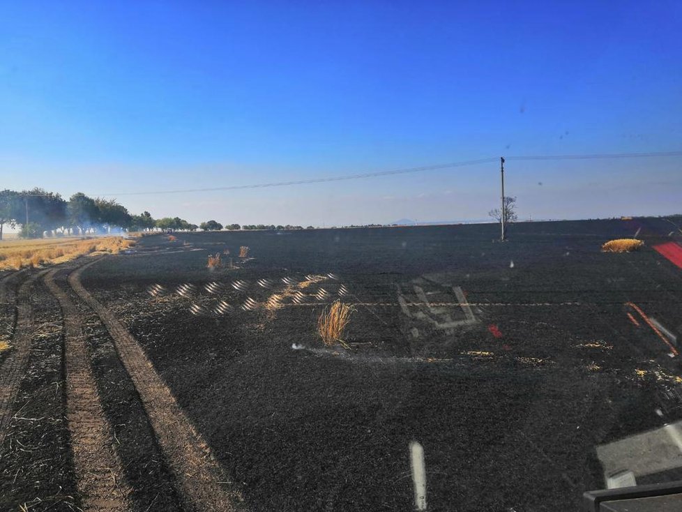 Opodál bývalých zemědělských skladů v Tursku hořelo odpoledne i pole, 16. července 2019.